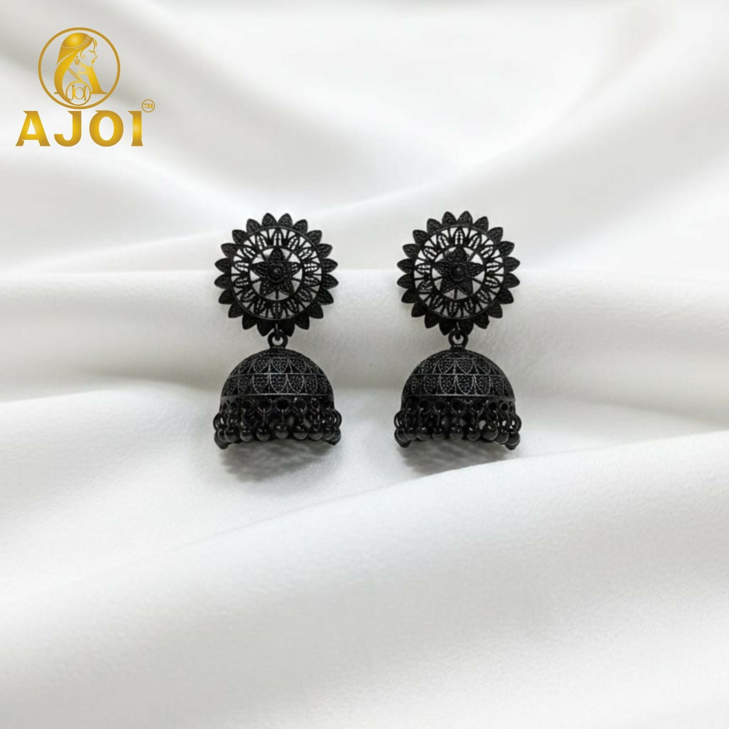 Close-up of carved patterns on black oxidized jhumka earrings
