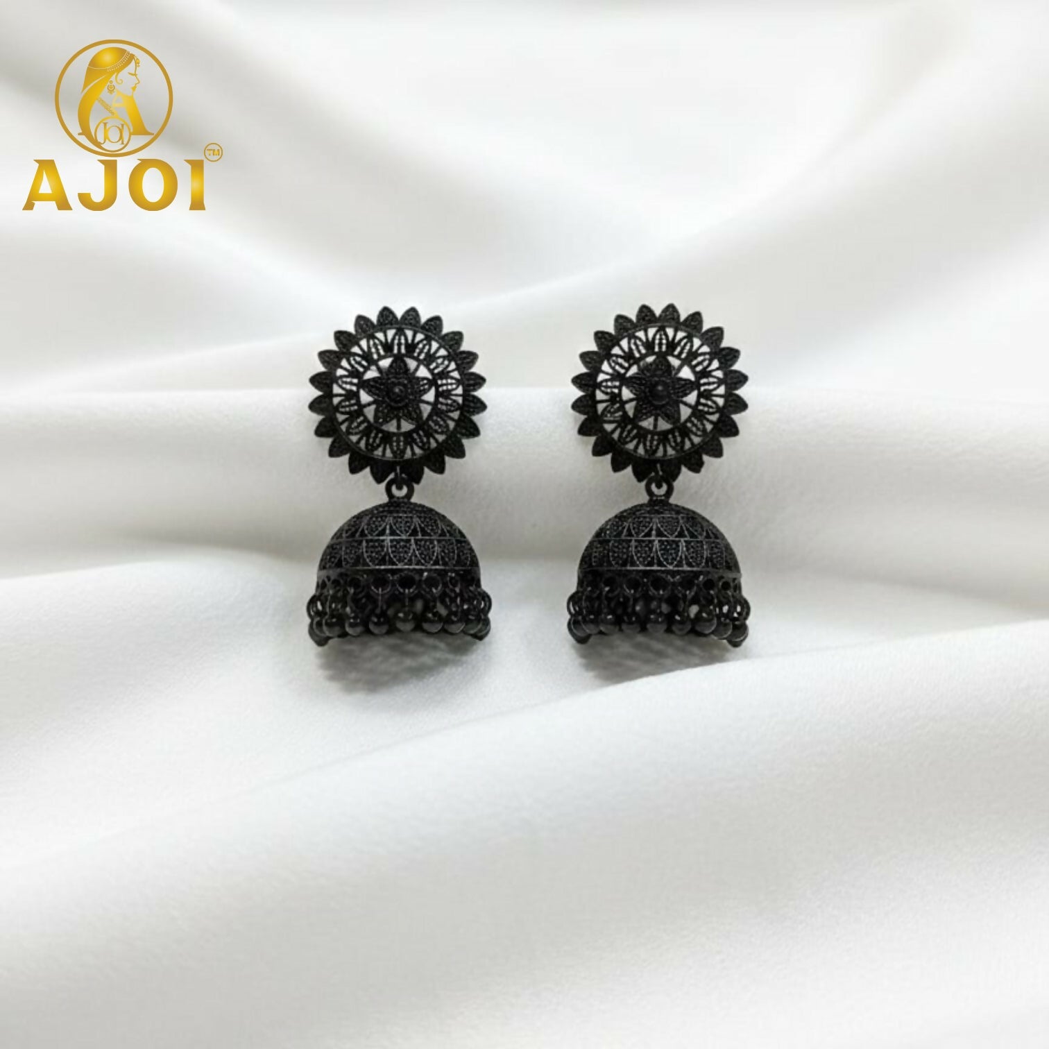 Close-up of carved patterns on black oxidized jhumka earrings