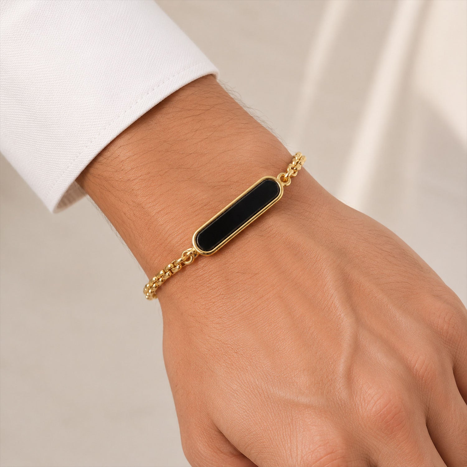 Side view of custom engraved black enamel name bracelet on a clean background.