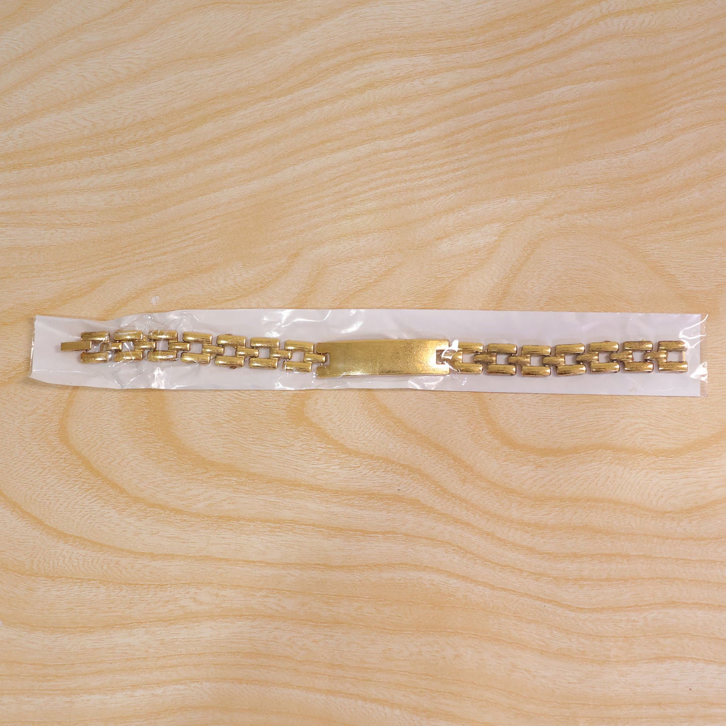 Multiple personalized gold-plated bracelets stacked, demonstrating various custom name options.