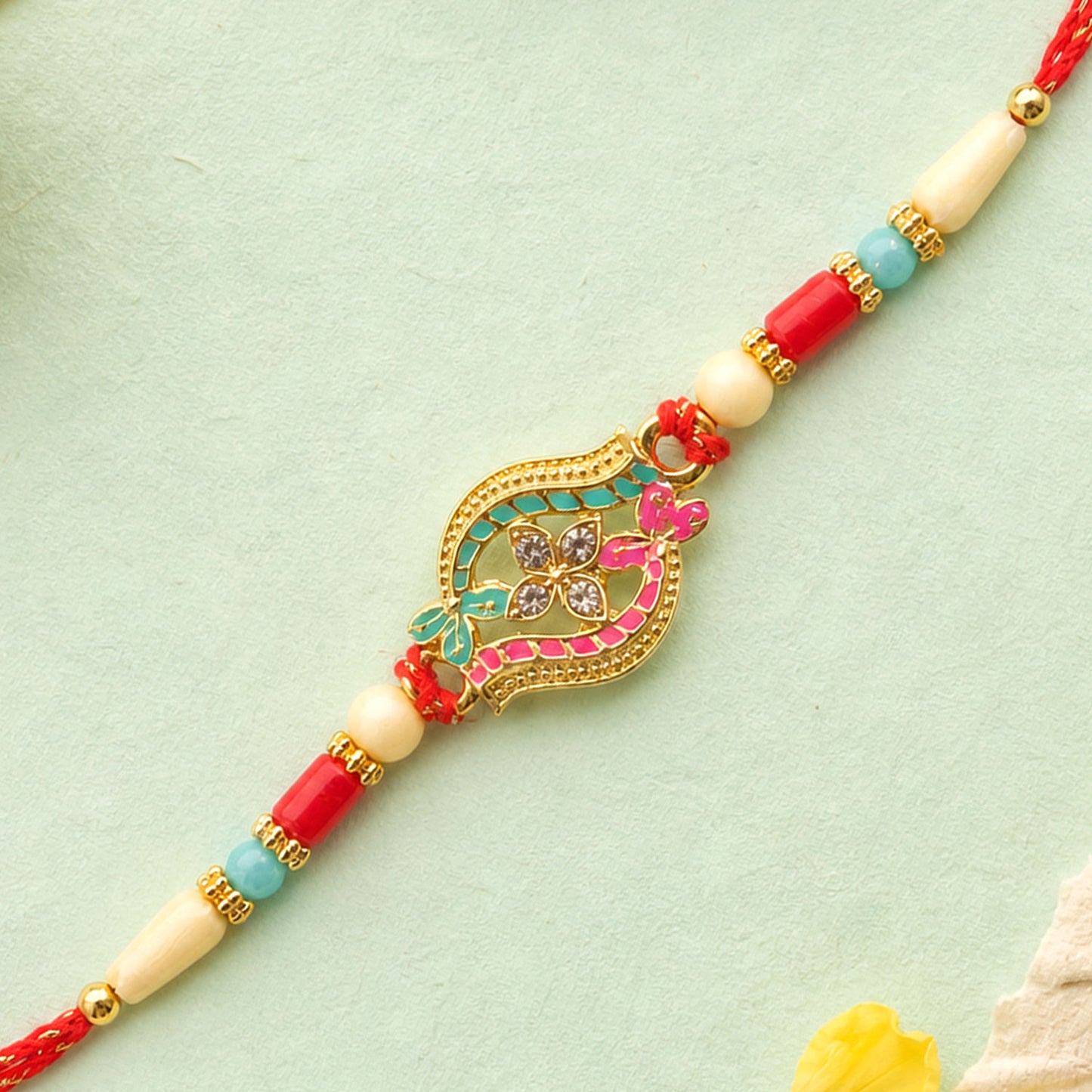 Golden Filigree Oval Floral Centerpiece Rakhi with Pink & Turquoise Enamel Detail