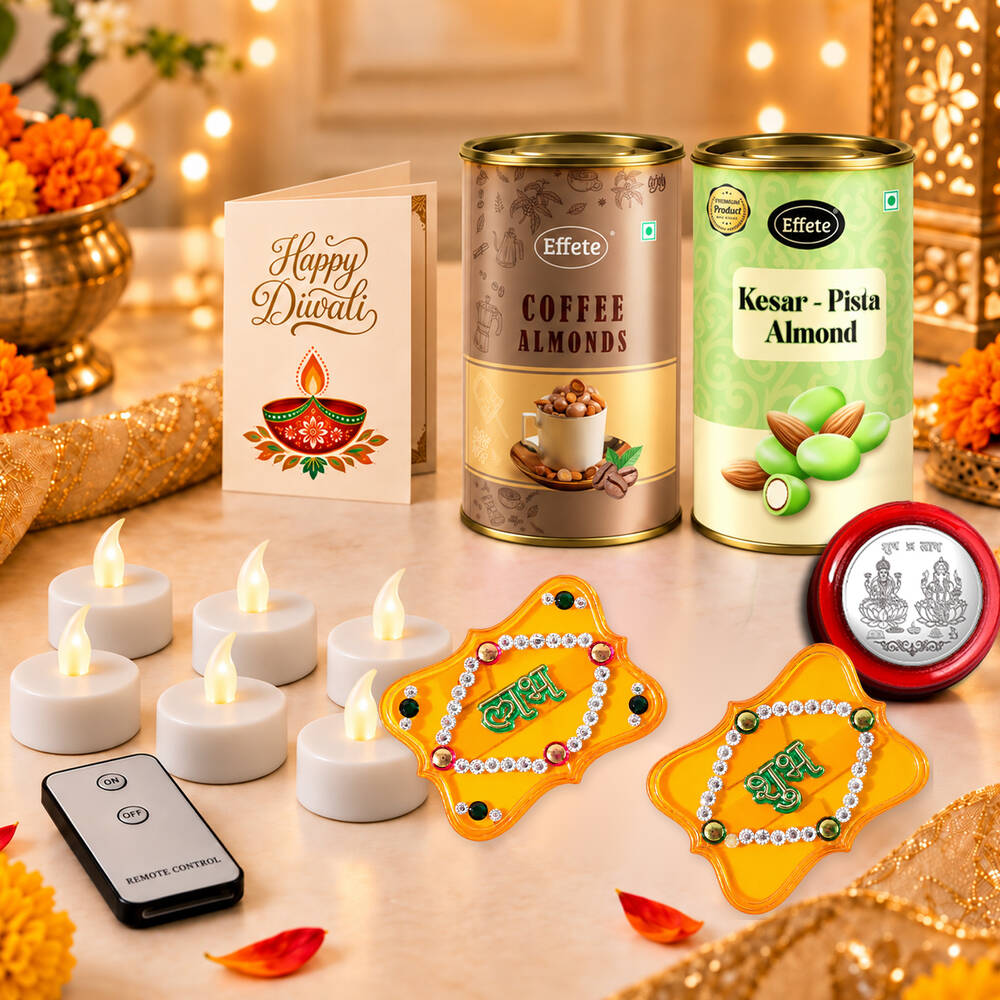 A festive arrangement of a Diwali card, two almond tins, six glowing LED tealights, a remote, two yellow Shubh Labh