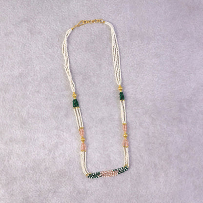 Side view of traditional beaded mala necklace with green and peach accents