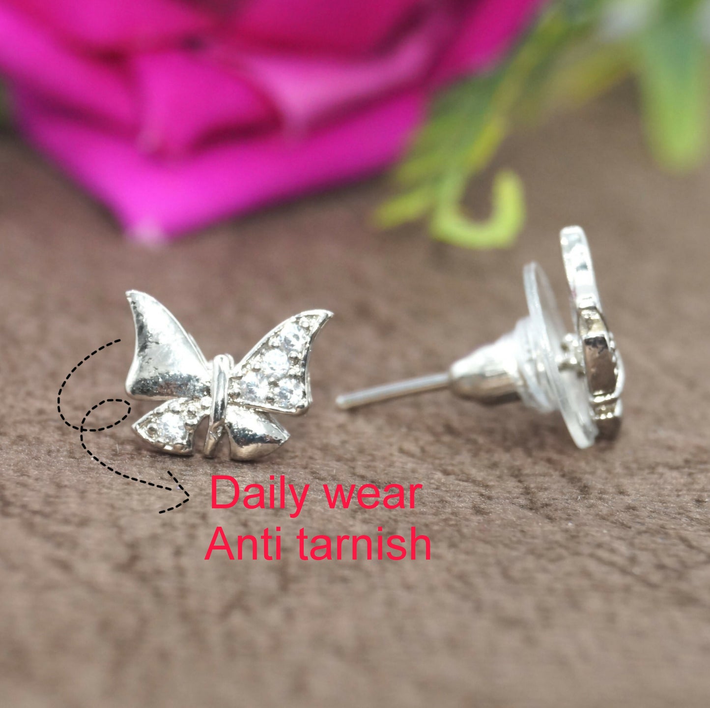 Pair of sterling silver butterfly stud earrings with cubic zirconia stones on a white background