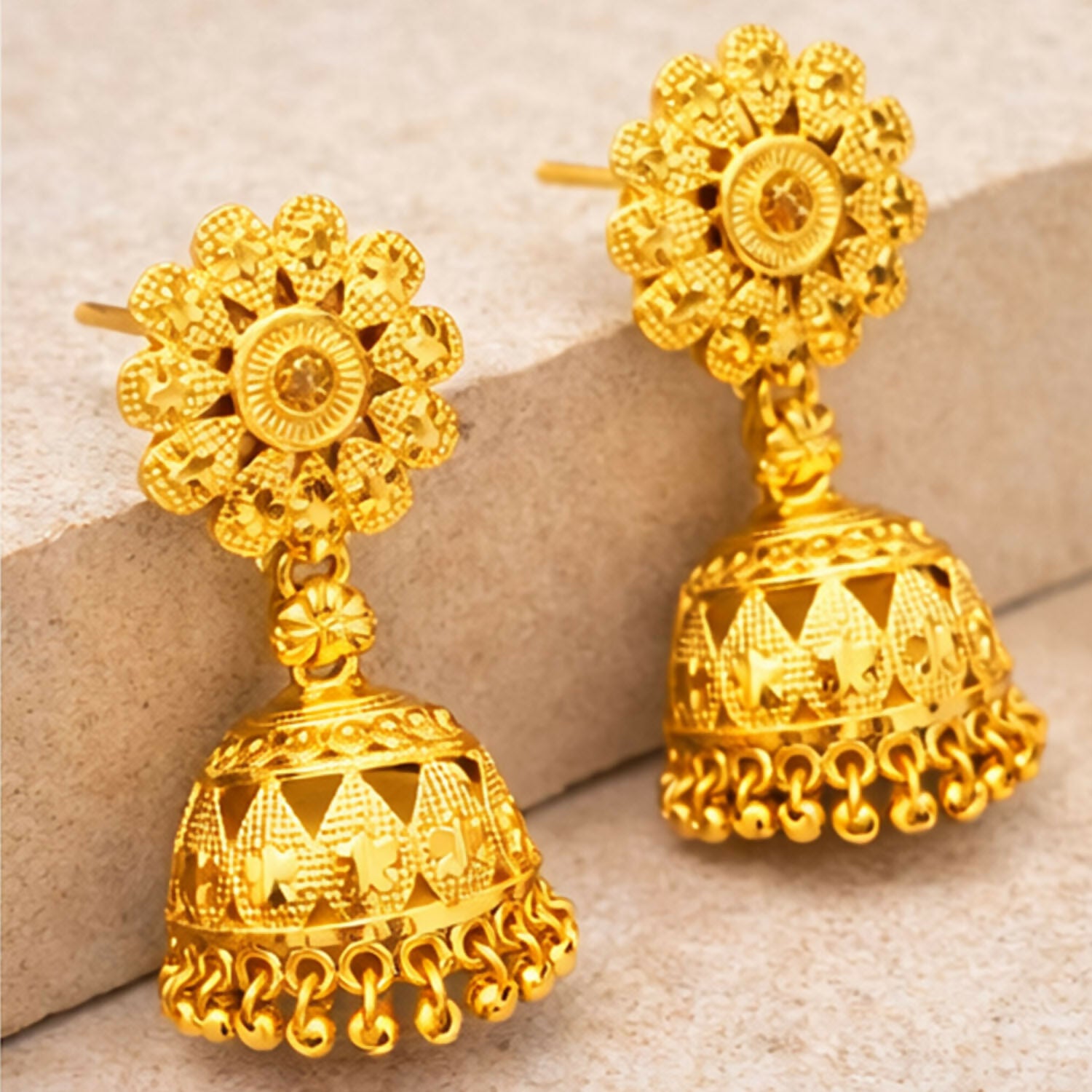 Pair of gold plated jhumka earrings styled with ethnic Indian attire