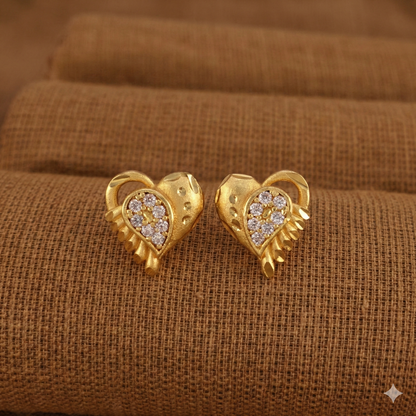 Elegant gold-plated heart-shaped stud earrings showing hammered texture and crystal detailing