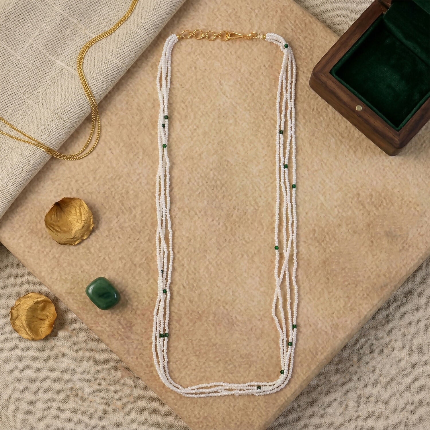 Woman wearing elegant white beaded mala with green accents