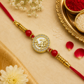 Divine Gold-Plated 'Mahadev Trishul & Damru' Dial Rakhi with Rhinestone Frame & Red Beads