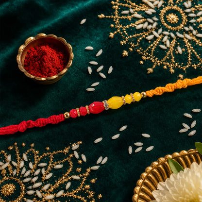 Red Thread Rakhi with Yellow and Orange Bead Pendant Accents