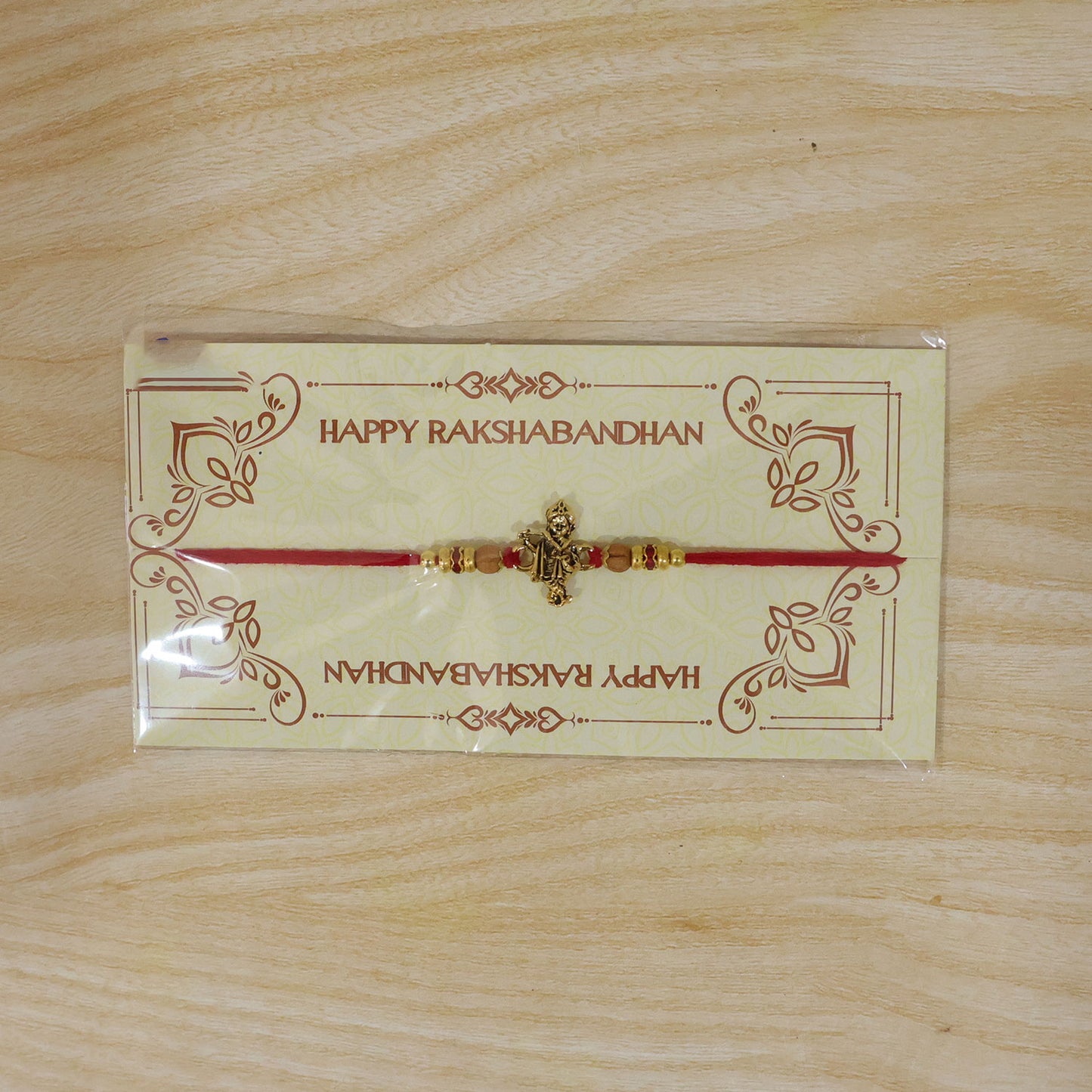 Krishna Flute Idol Devotional Rakhi with Golden Centre, Wooden Beads and Red Thread