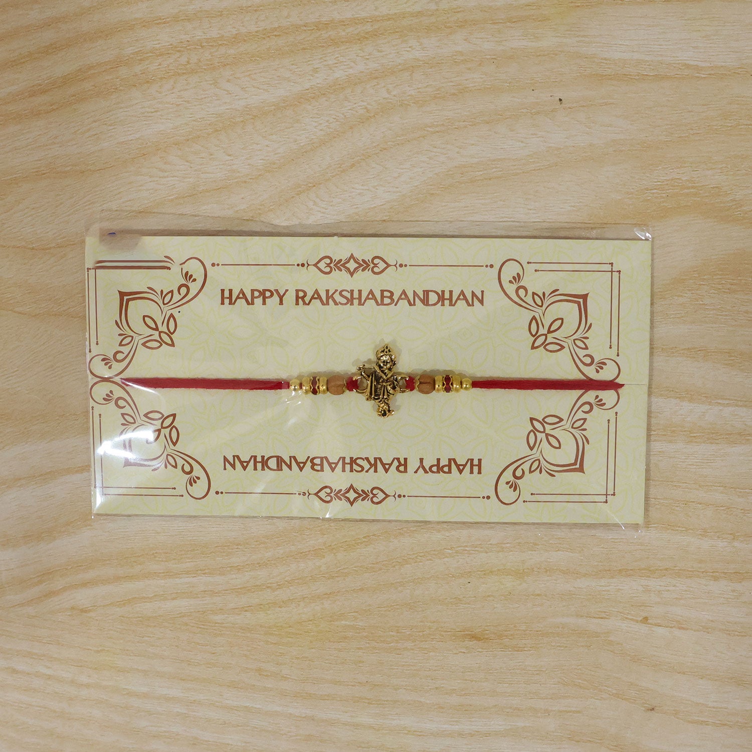 Krishna Flute Idol Devotional Rakhi with Golden Centre, Wooden Beads and Red Thread