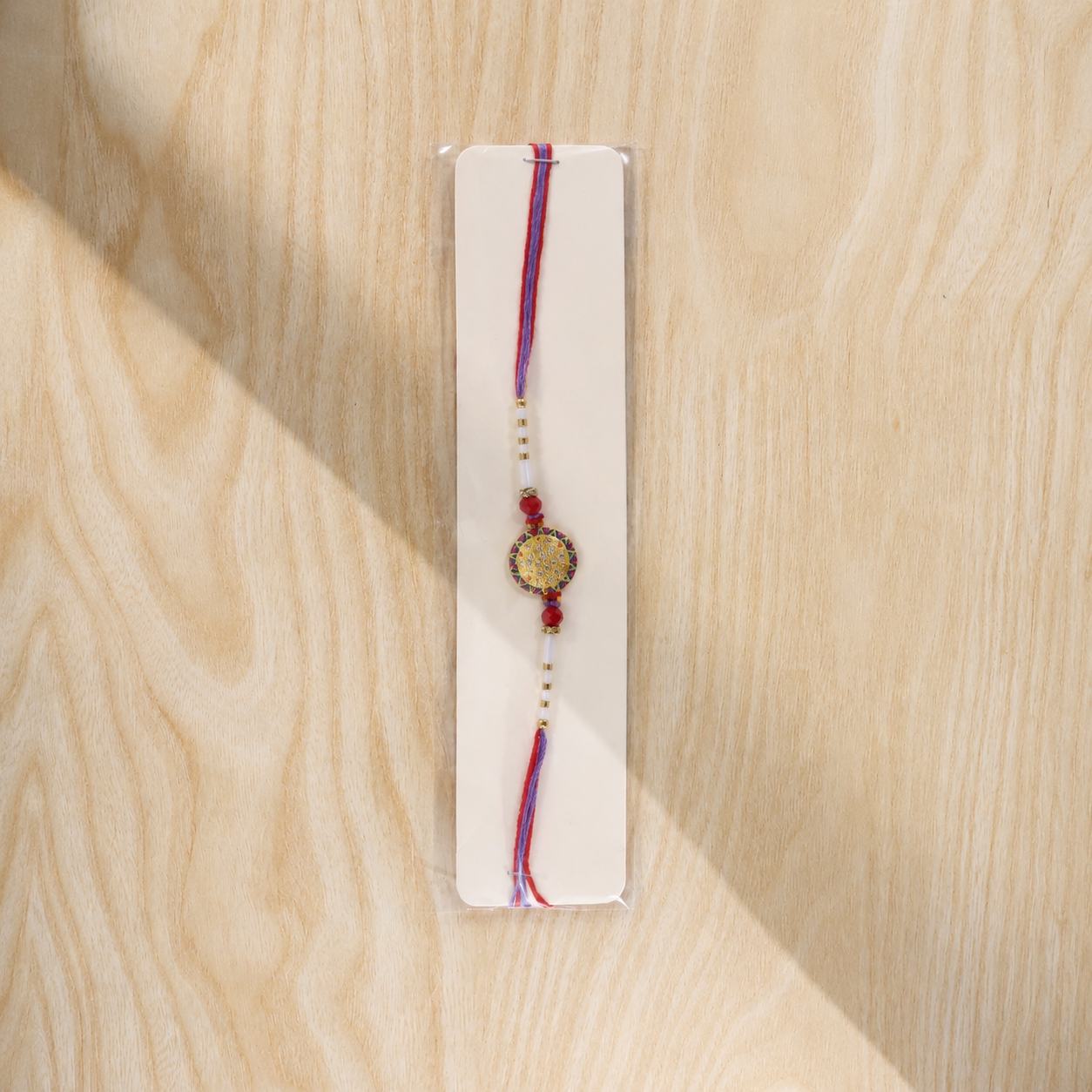 Soft Gold Round Rakhi with White Beads and Dual Color Thread