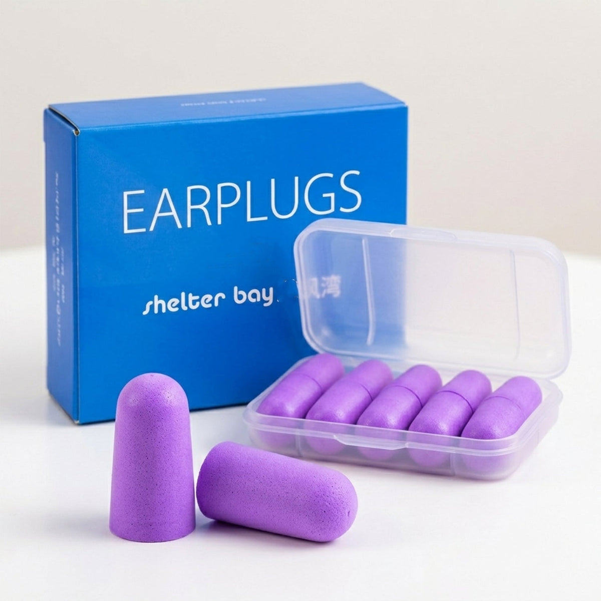 A blue box labeled "EARPLUGS" stands behind an open clear plastic case containing five pairs of purple foam earplugs.