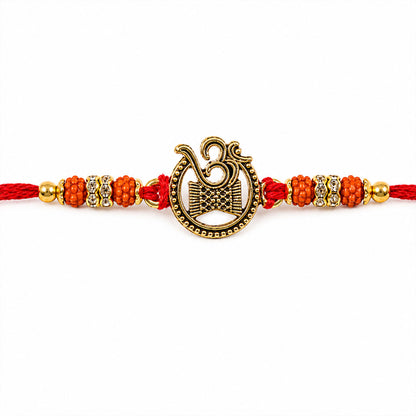 Om Damru Trishul Devotional Rakhi with Golden Centre, Orange Beads and Red Thread