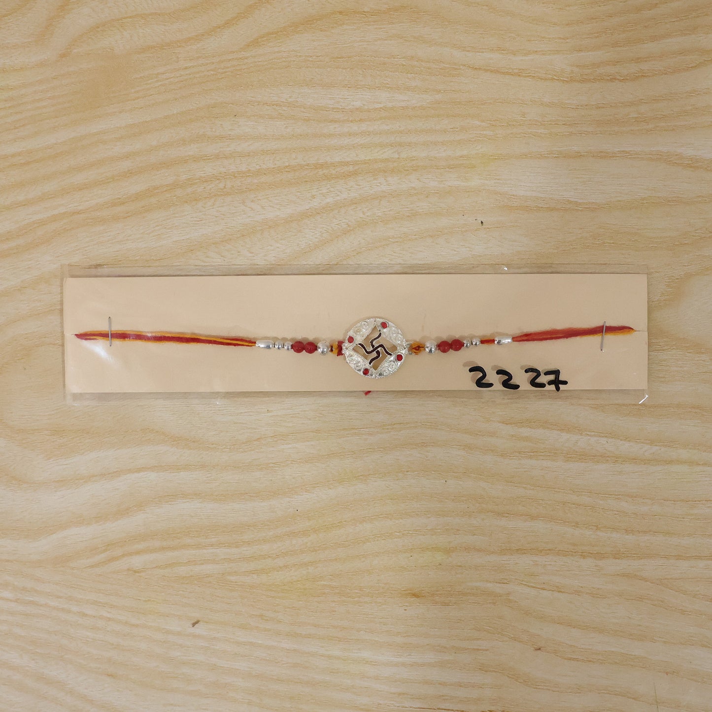 Silver Swastik Stone Rakhi with Red Thread and Handmade Look