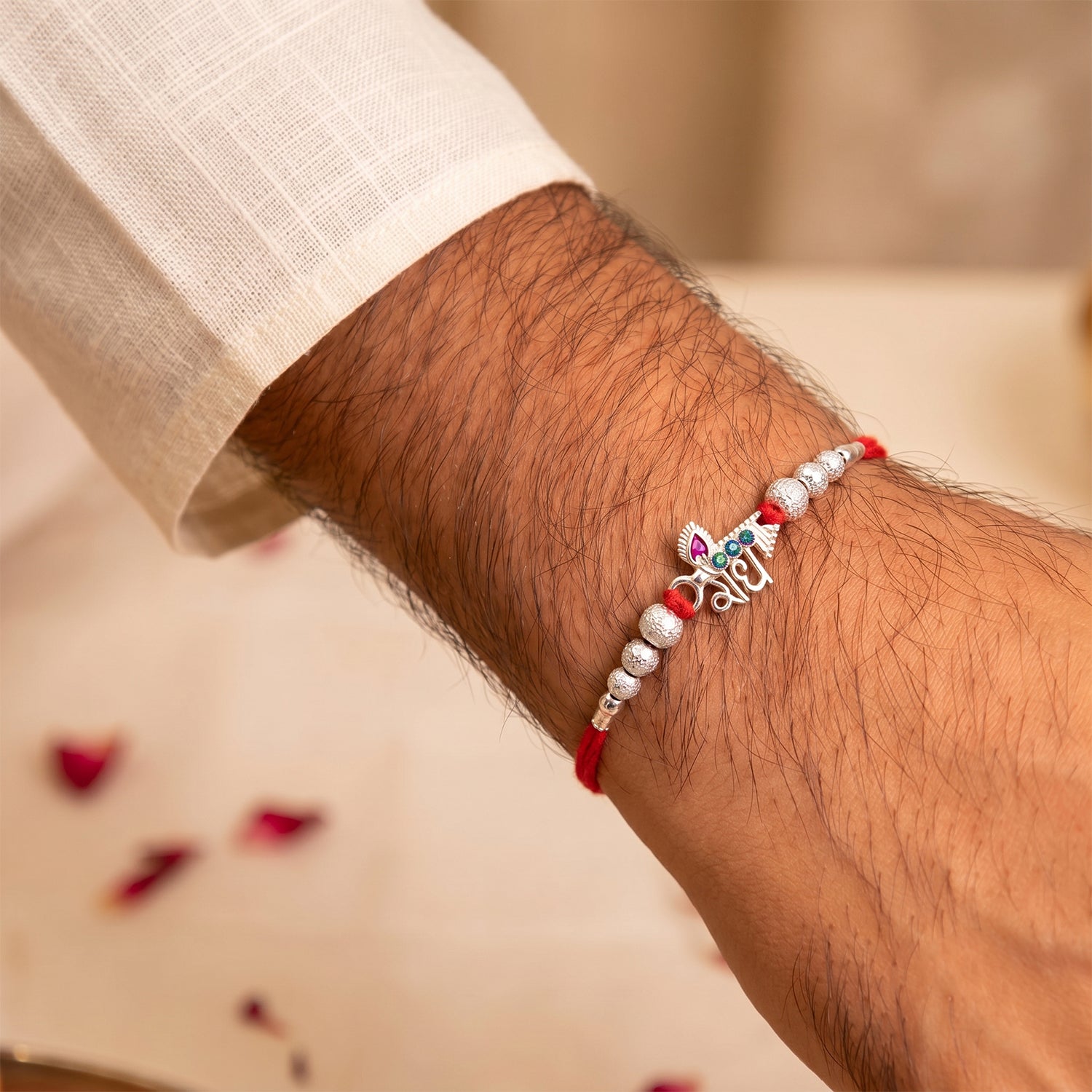 Elegant Radhe Silver Rakhi with Decorative Beads and Red Thread