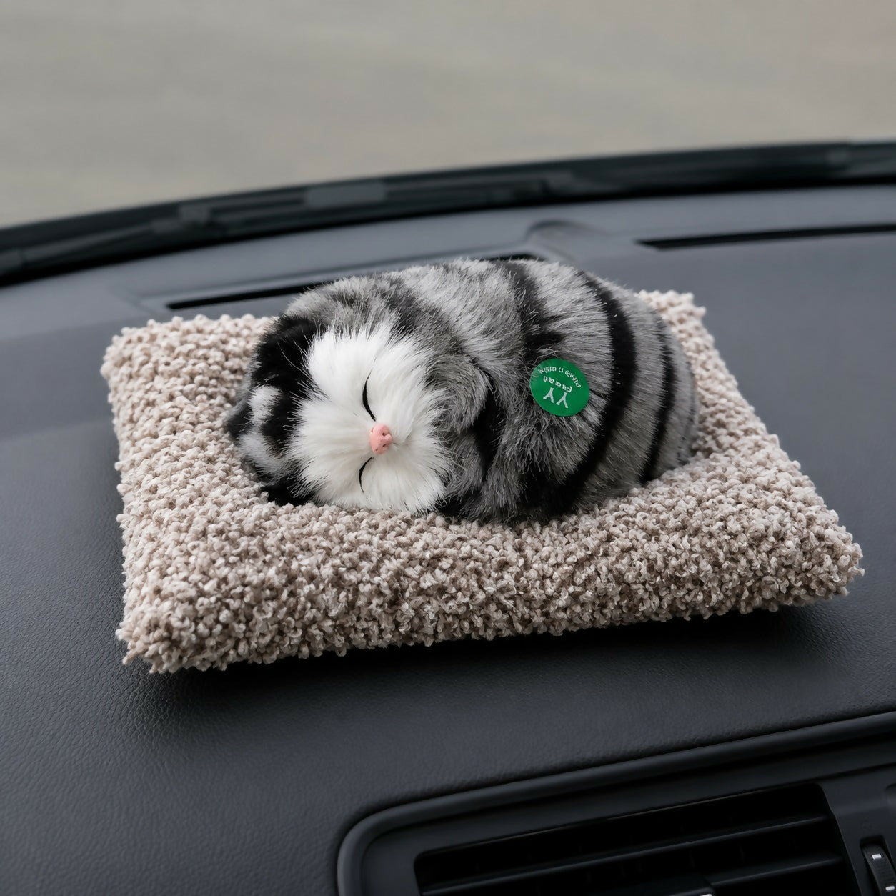 Sleeping cat plush toy on cushion for car dashboard