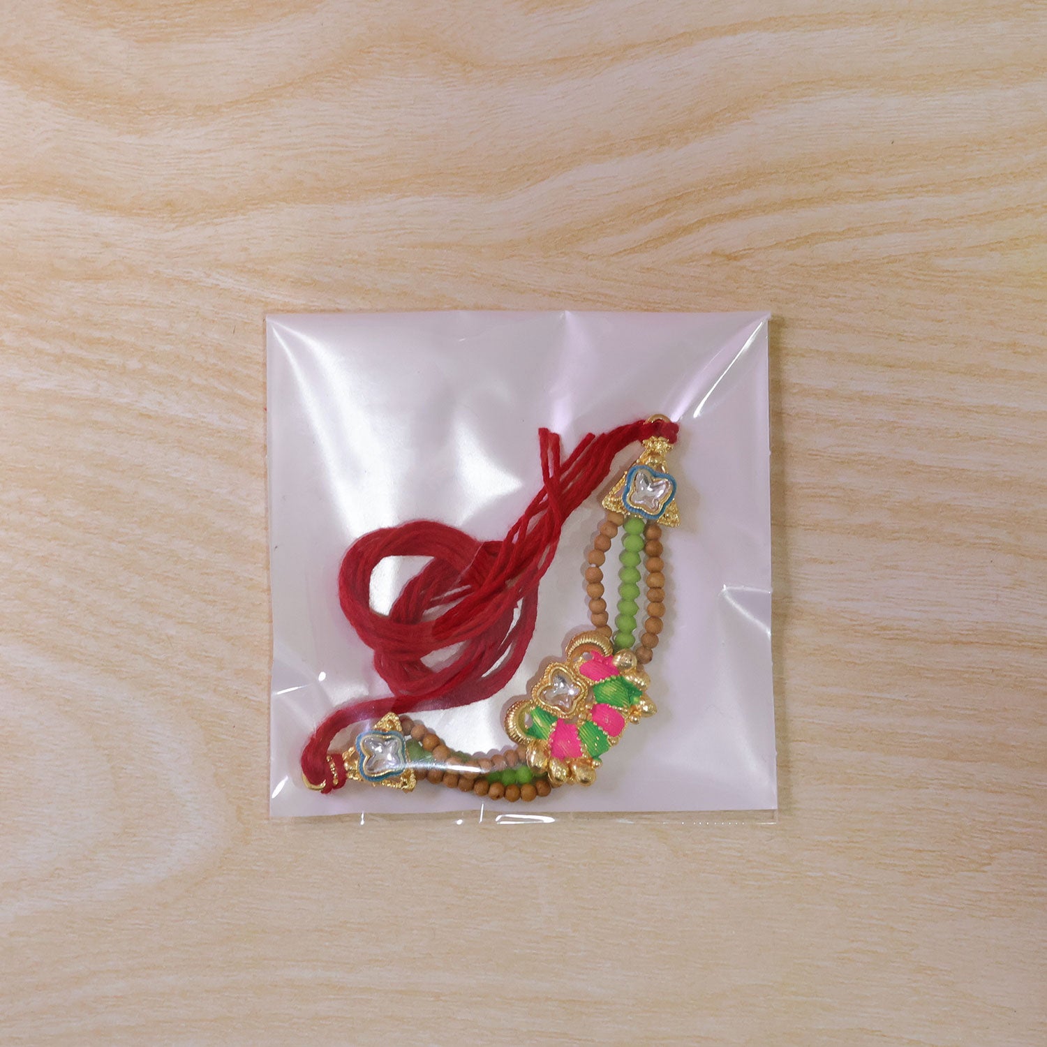 Green Beaded Floral Rakhi with Pink Center and Colorful Festive Gifting Elegance