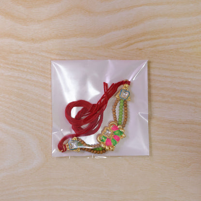 Green Beaded Floral Rakhi with Pink Center and Colorful Festive Gifting Elegance
