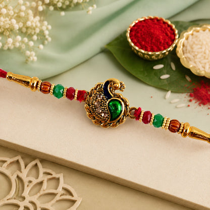 Green Peacock Paisley Rakhi with Golden Detail, Festive Beads and Red Thread