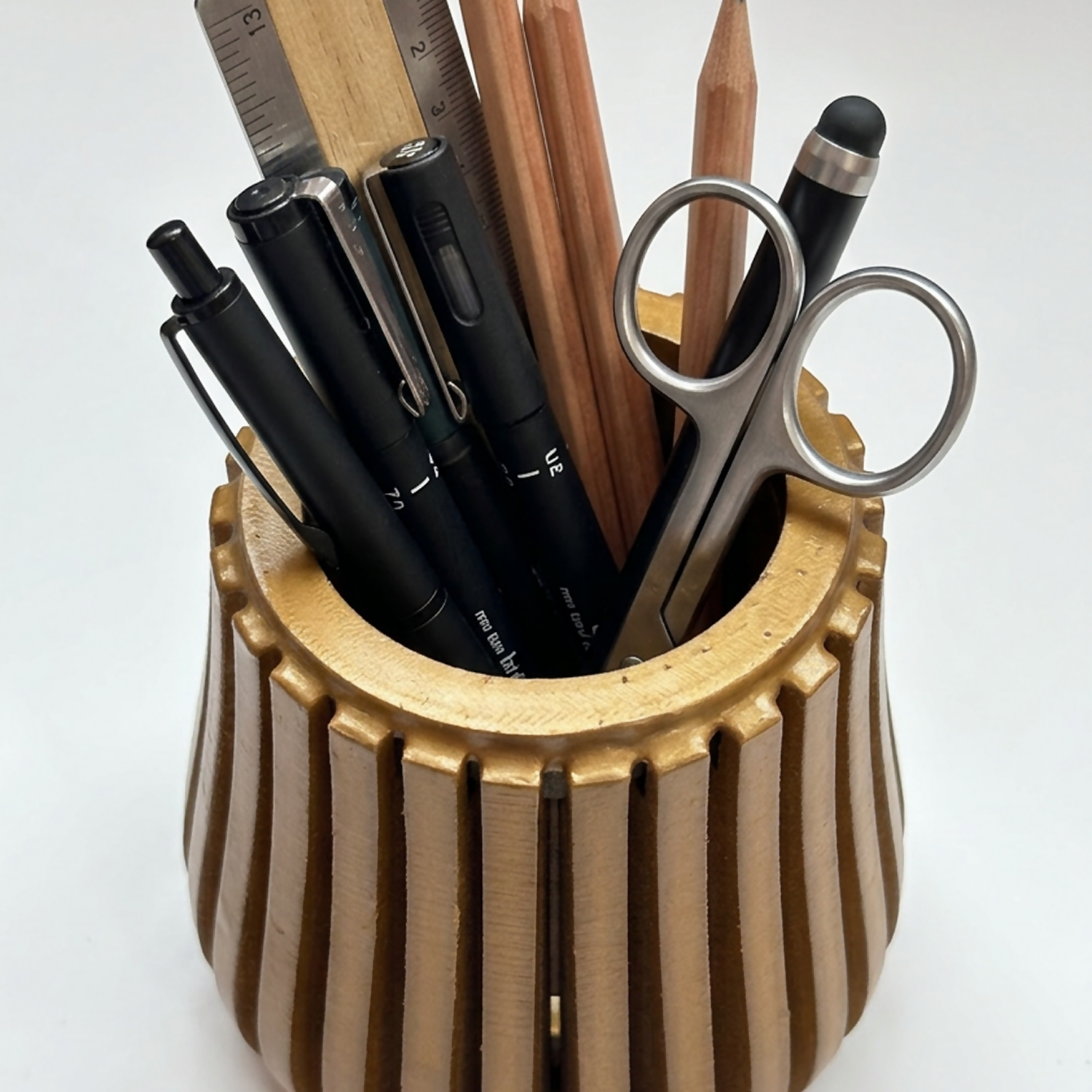 Modern wooden desk organizer stand holding various pens, pencils, and office supplies.