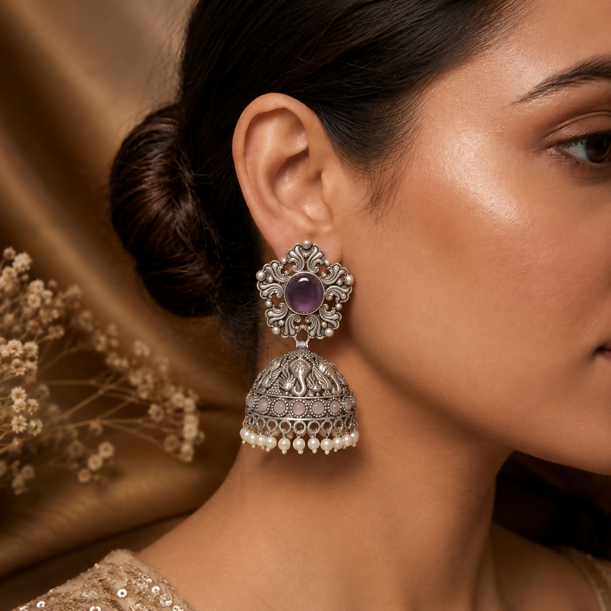 Detail of intricate vintage design on oxidized silver jhumka earrings