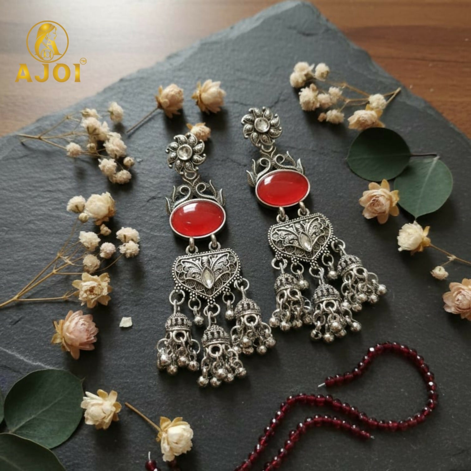 Vintage-Inspired Oxidized Silver Red Stone Jhumka Earrings with Ornate Filigree Design and Cascading Bell Danglers