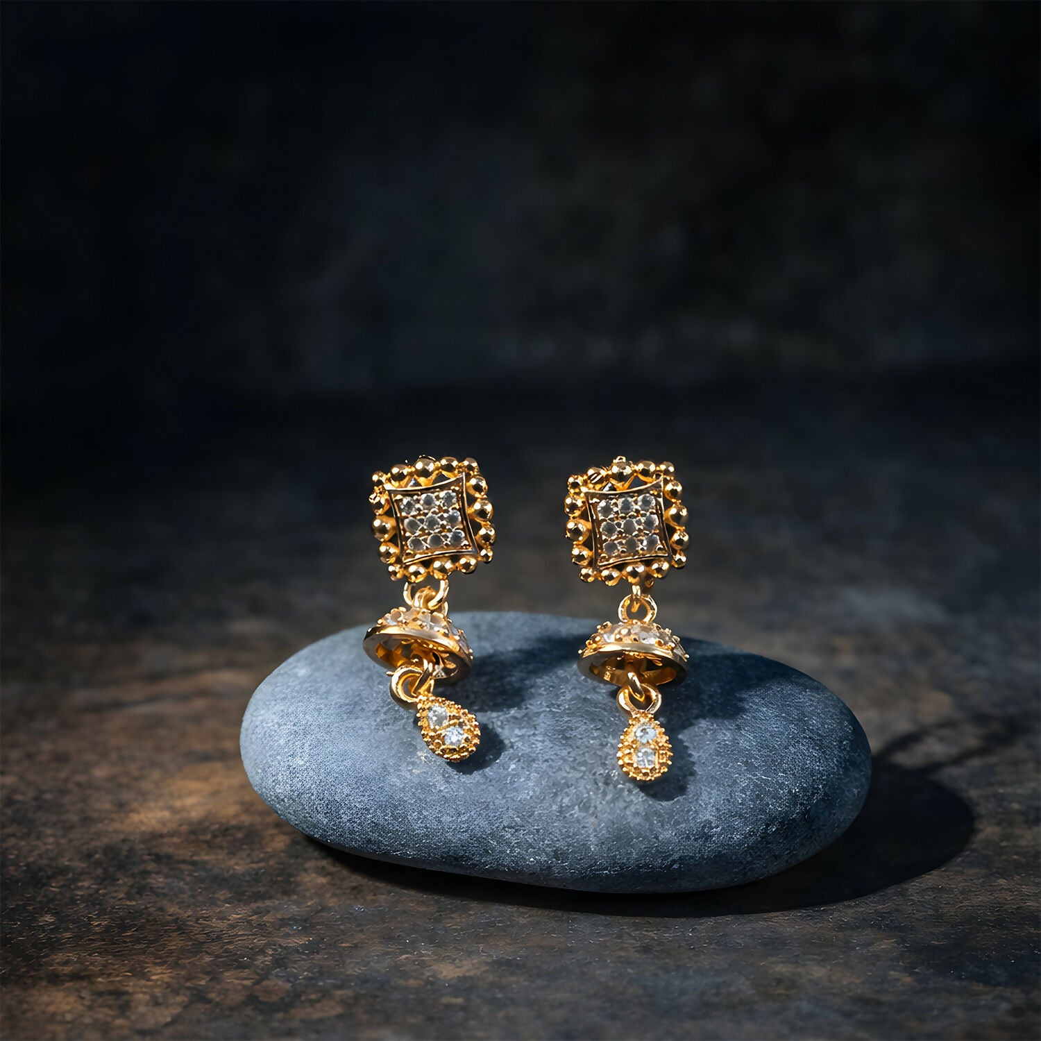 Side view of layered gold Jhumka drop earrings featuring teardrop charms