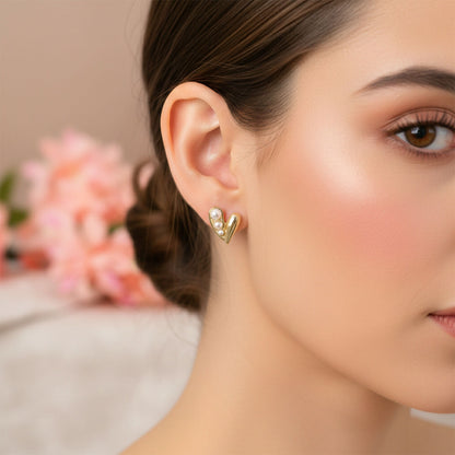 Gold pearl heart stud earring worn on ear