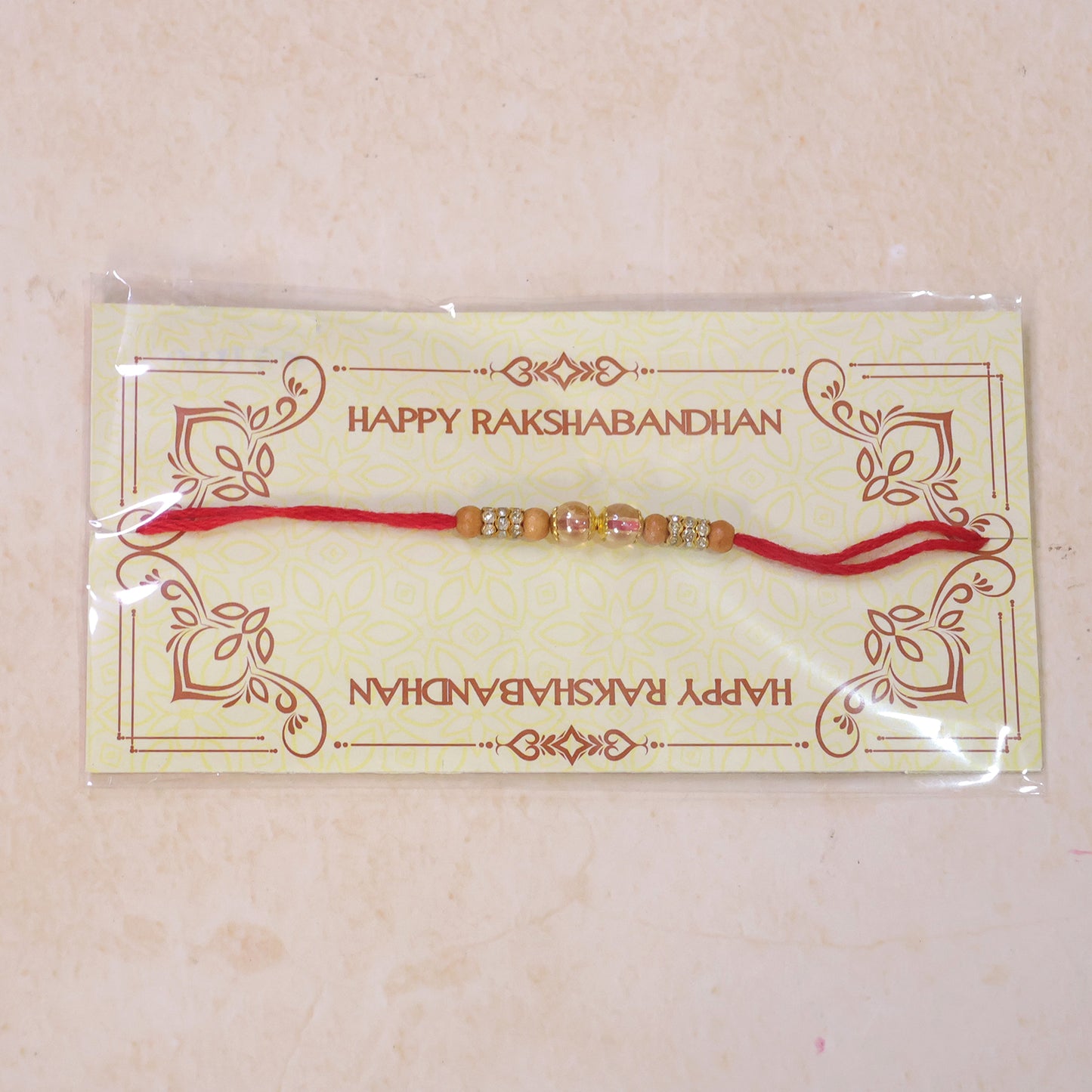 Red Thread Rakhi with Wooden Bead and Dusty-Pink Crystal Accents