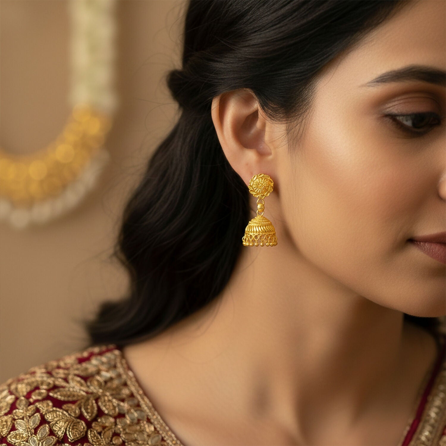 Close-up of elegant gold jhumka earrings with hanging beads