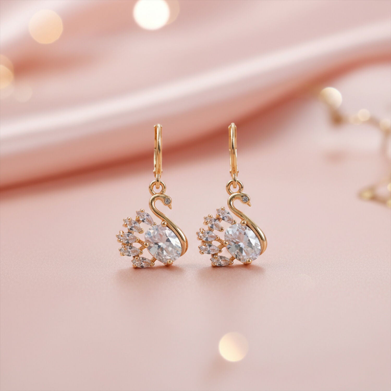 Pair of swan design stone drop earrings with polished finish displayed