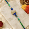 Golden Lord Krishna Flute Enamel Medallion Rakhi with Ocean Blue Crystals