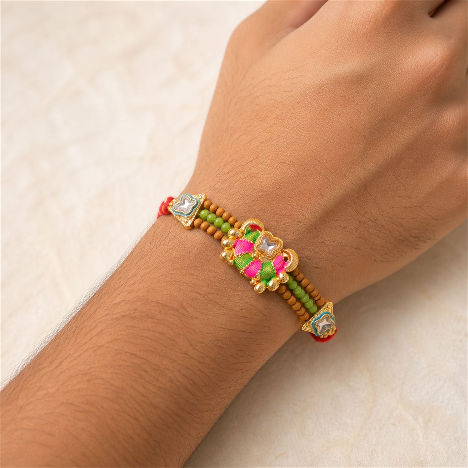 Green Beaded Floral Rakhi with Pink Center and Colorful Festive Gifting Elegance