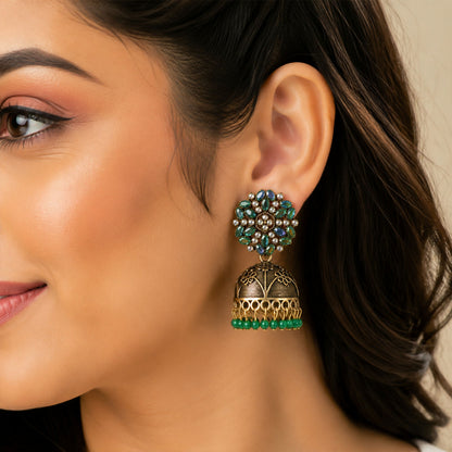 Side view of antique golden jhumka earrings with green bead hangings