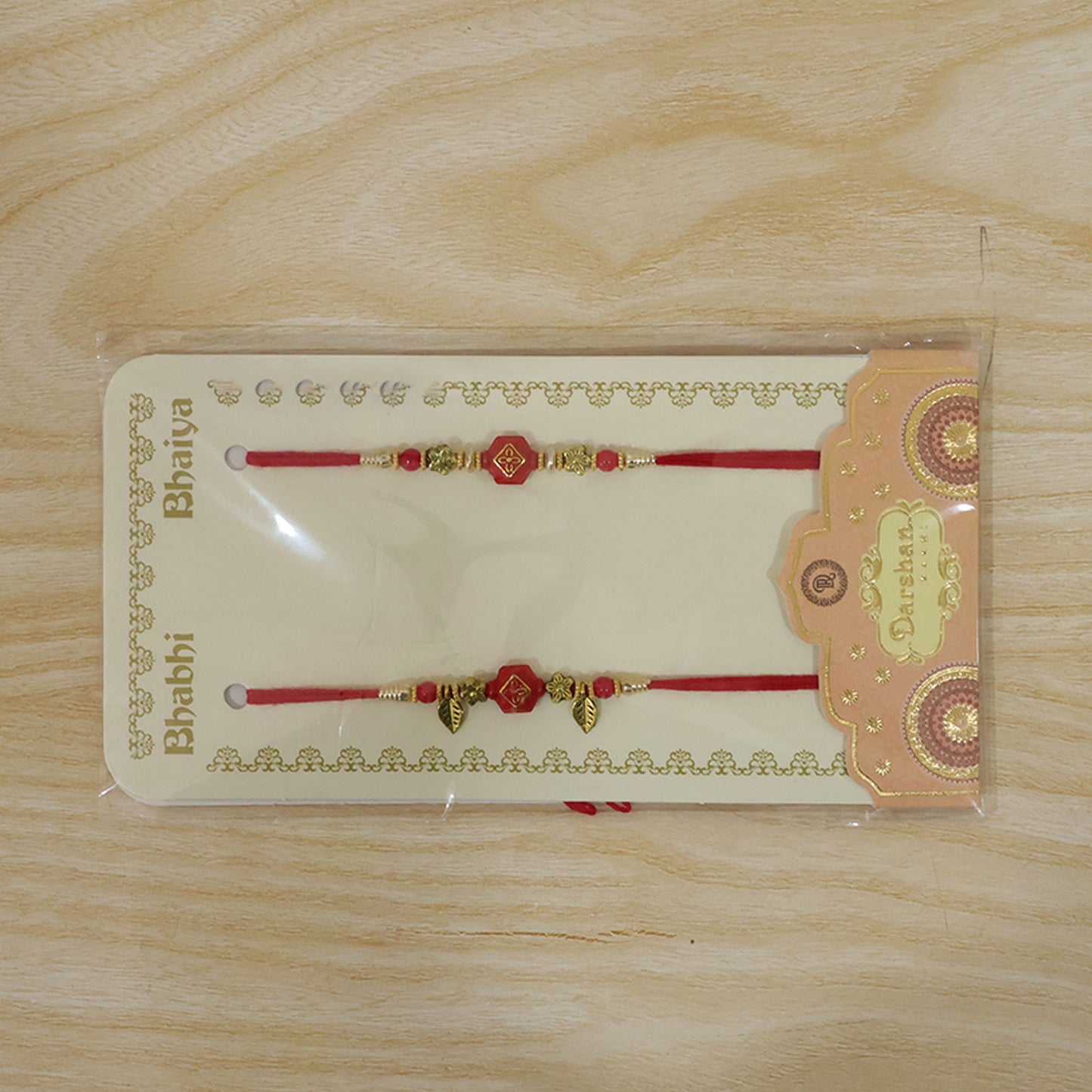 Couple Rakhi with Red Hexagon Charm, Gold Beads and Leaf Accents