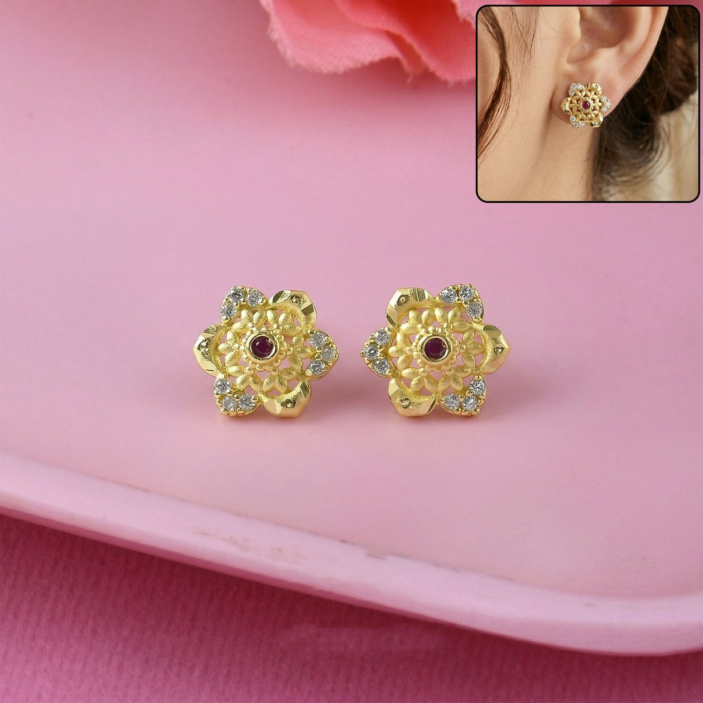 Close-up of gold stud earrings with floral design and sparkling center stone