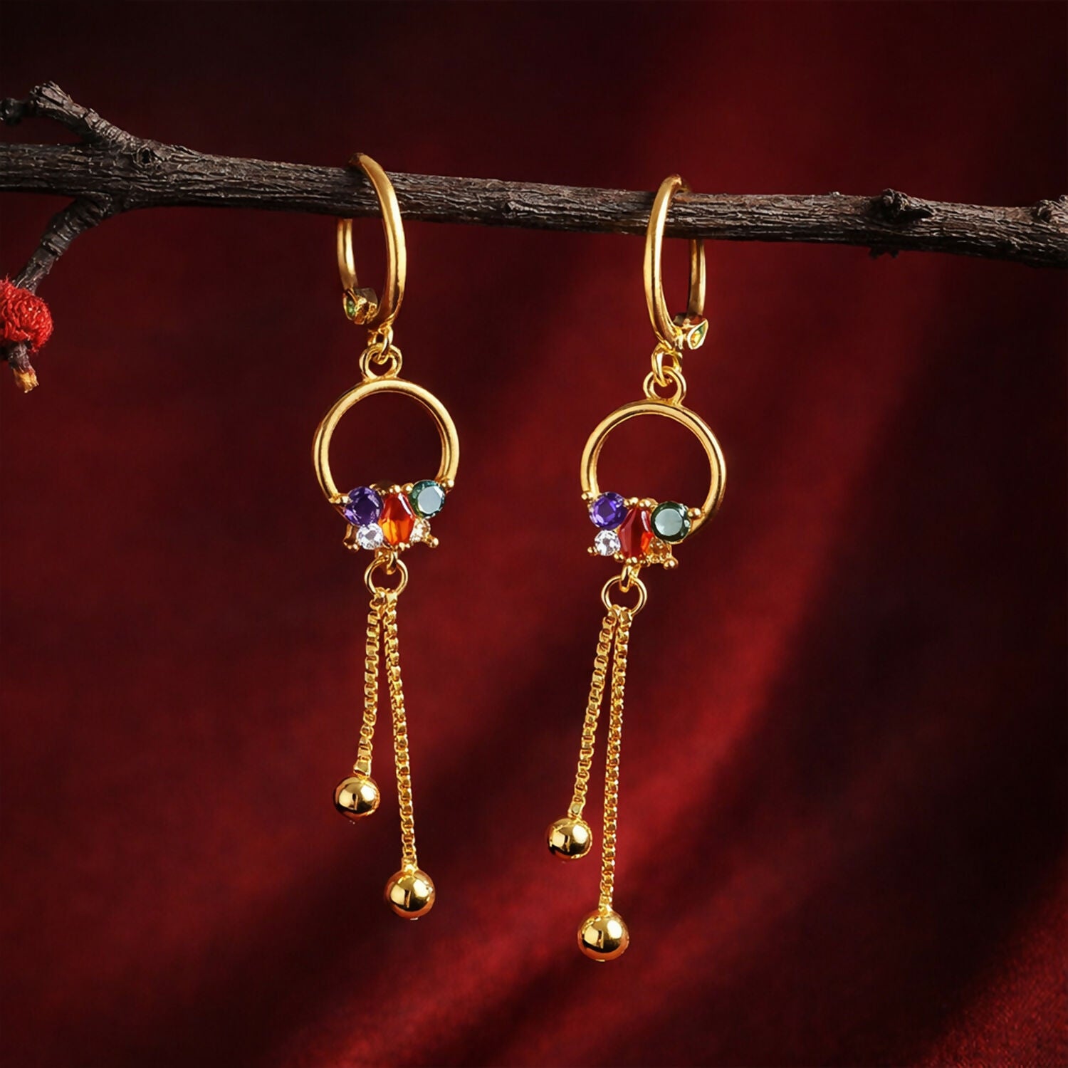 Side view of gold finish circular drop earrings displaying elegant chain tassel details