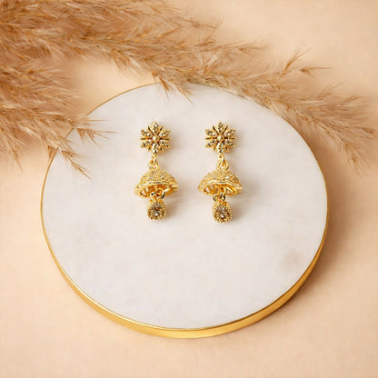 Pair of sunburst floral gold finish jhumka earrings showcasing detailed crystal embellishments