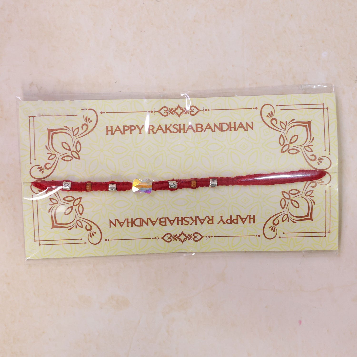 Red Braided Rakhi with an Iridescent Bow-Tie Shaped Crystal Bead