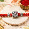 Red Thread Rakhi with a Bold Silver Om Pendant and Red Beads