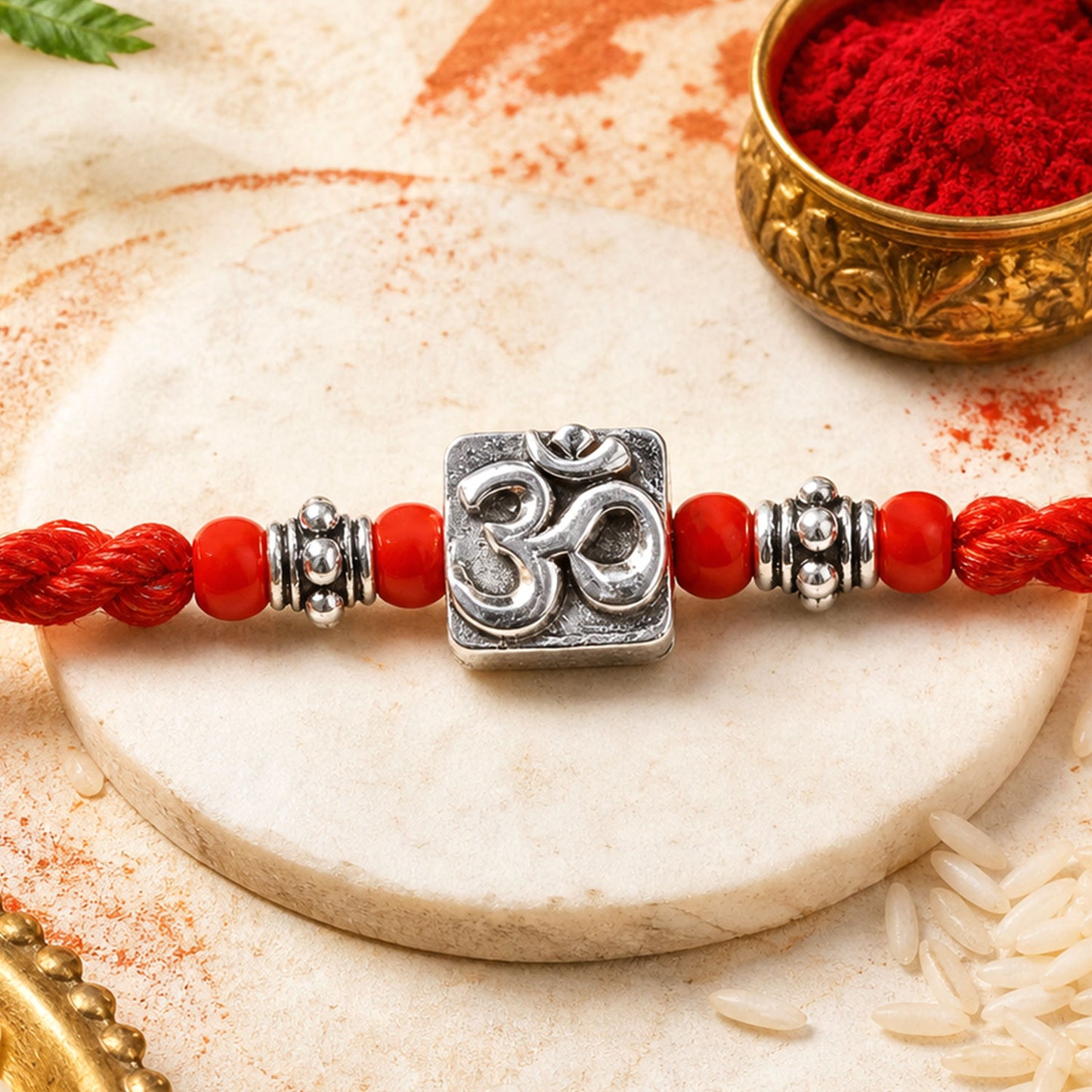 Red Thread Rakhi with a Bold Silver Om Pendant and Red Beads