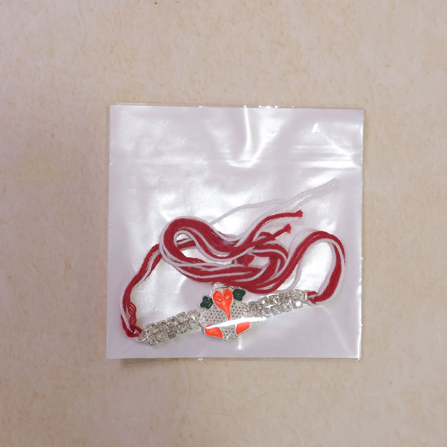 Silver-Toned Bal Ganesha Rakhi with Orange-Green Enamel, Double Crystal Chain & Red-White Thread