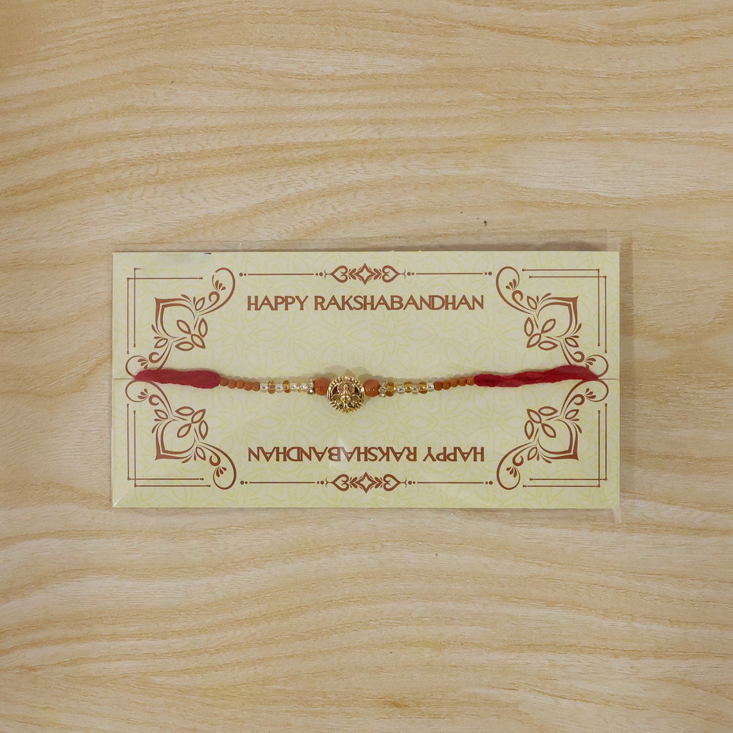 Lord Ganesha Golden Devotional Rakhi with Orange Beads and Crystal Highlights