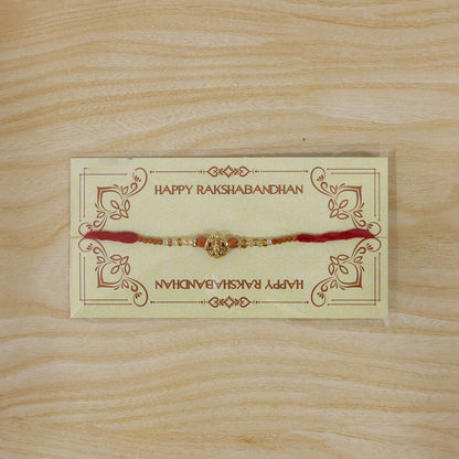 Lord Ganesha Golden Devotional Rakhi with Orange Beads and Crystal Highlights