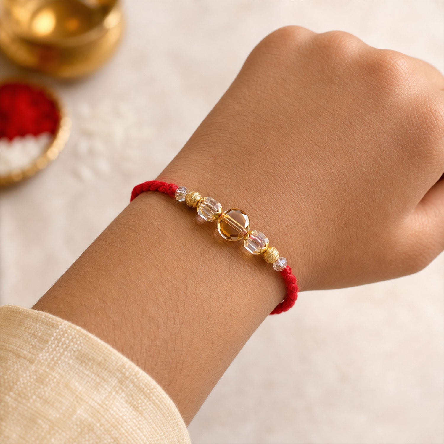 Red Thread Rakhi with Golden and Sparkling Crystal Bead Accents