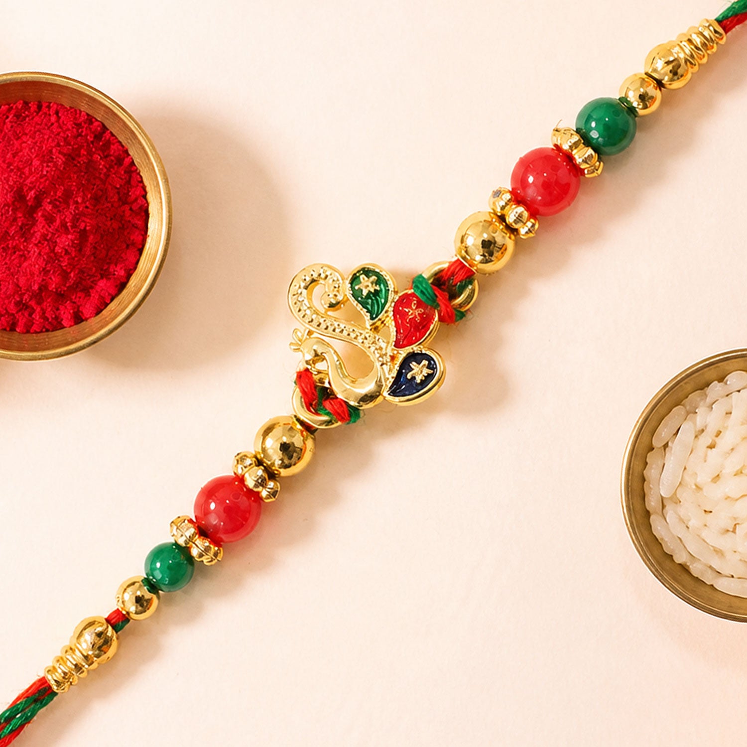 Colorful Enamel Peacock Pendant Rakhi with Red and Green Beads