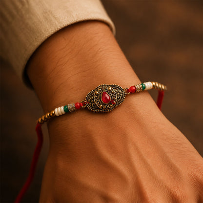 Antique Gold Teardrop Designer Rakhi with Red Stone, Roli Chawal Coin and Diya Gift Packing