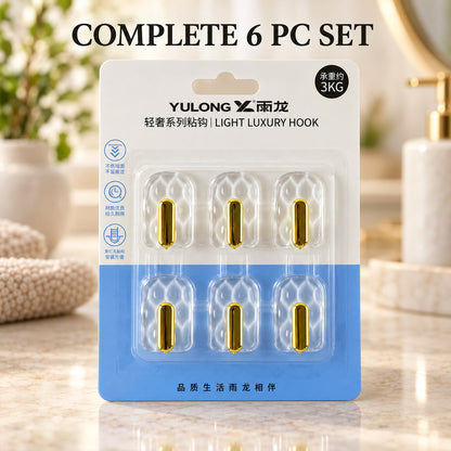 A blister pack containing six clear plastic hooks with gold accents, labeled as a "Light Luxury Hook" set.