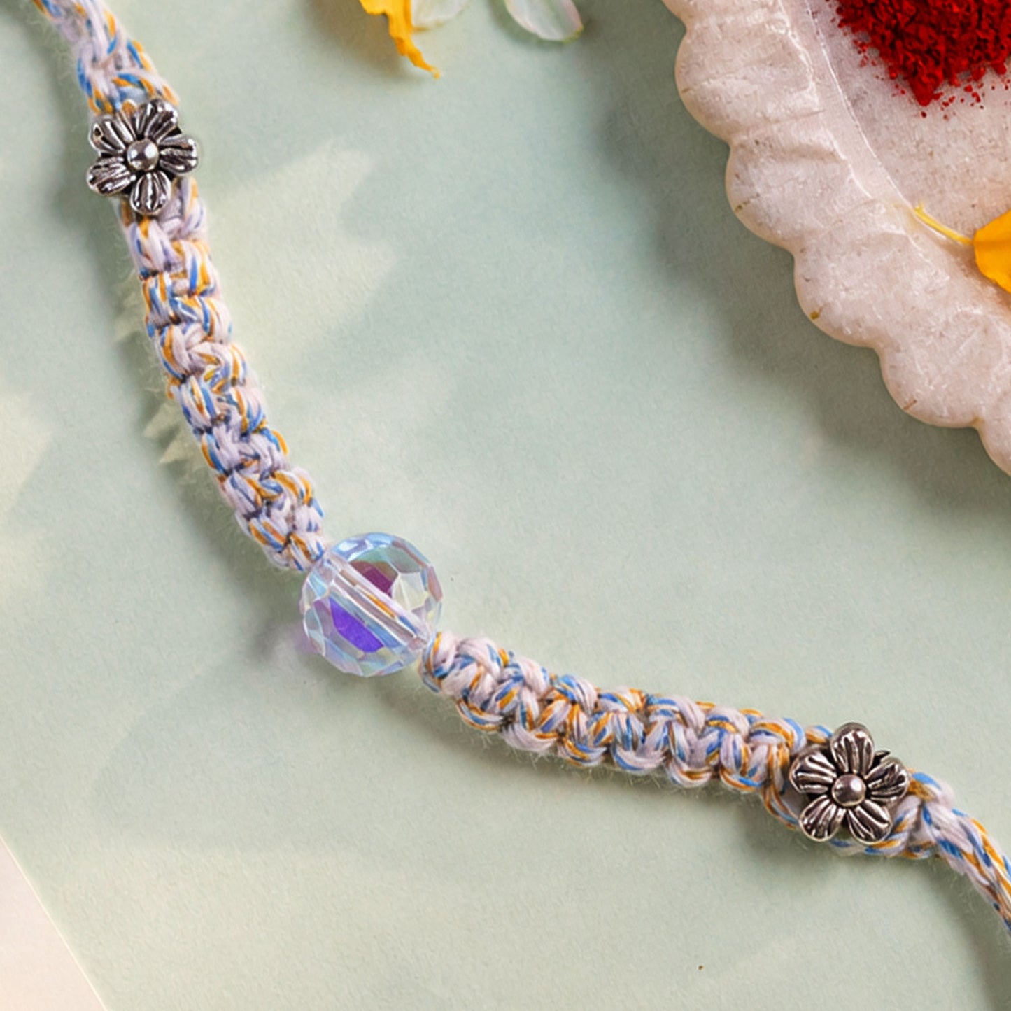 Pastel Braided Rakhi with Blue-White Thread and Crystal Bead Charm for Raksha Bandhan